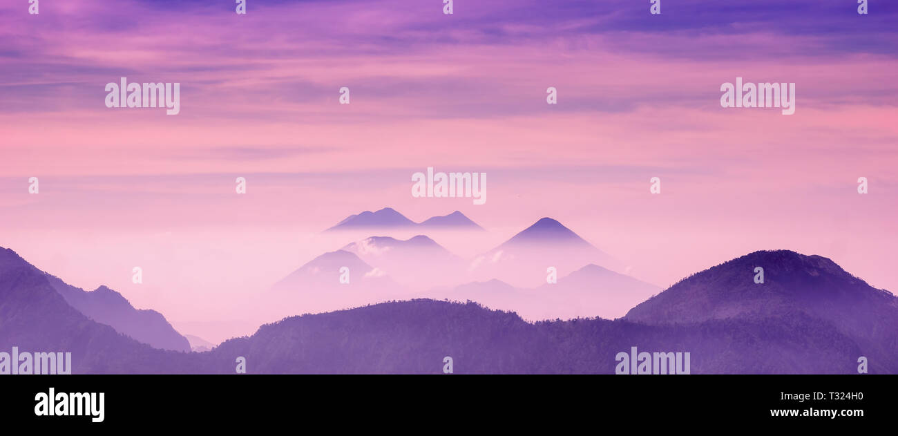 Skyscape view of cold purple mountains with mist and fog close to Quetzaltenango Stock Photo