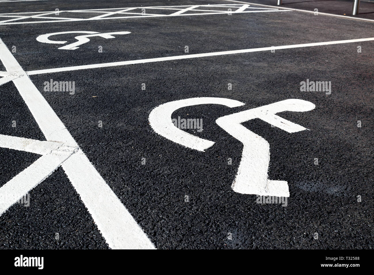 Disability wheelchair markings painted on Tarmac surface. Stock Photo