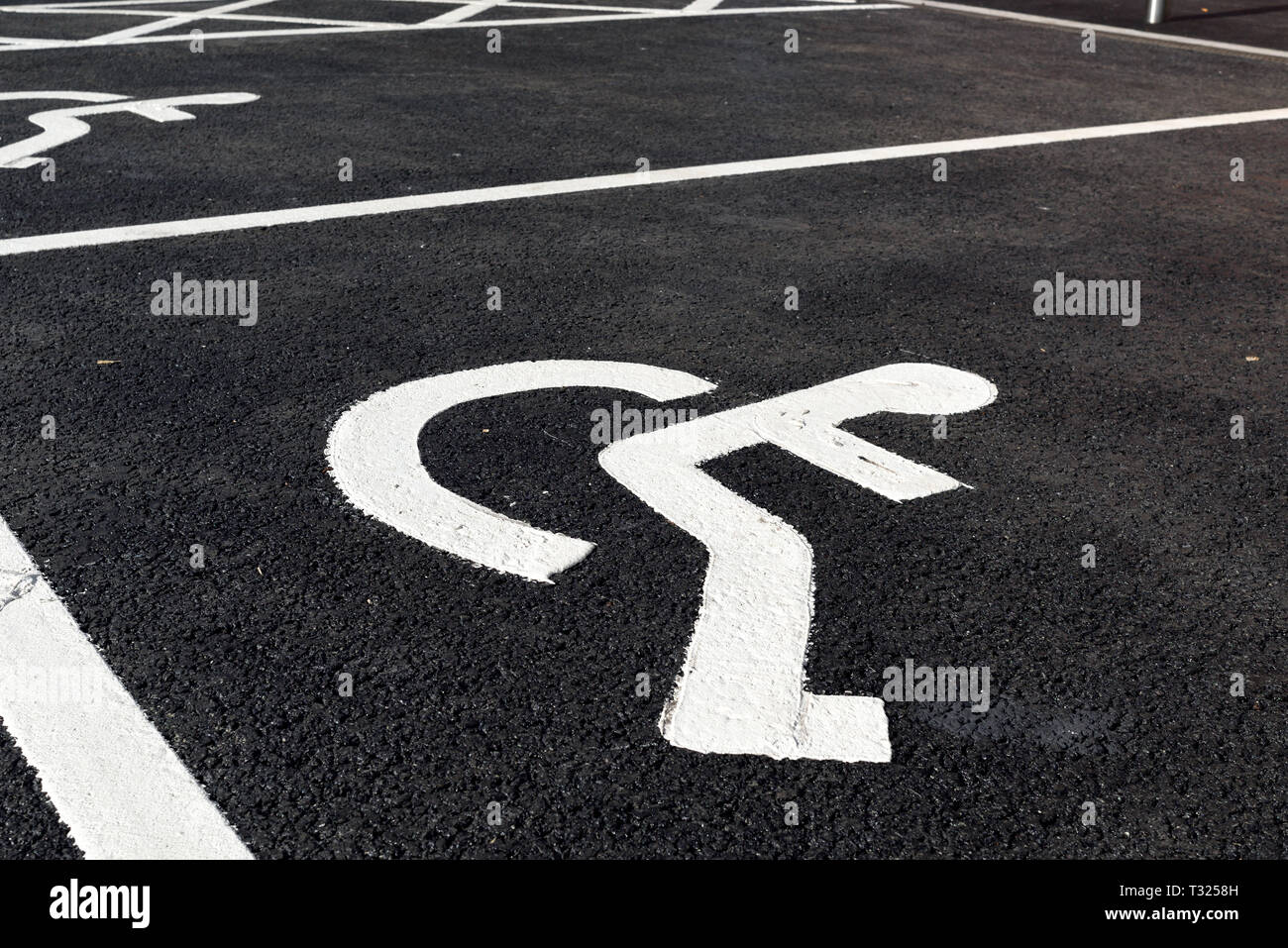 Disability wheelchair markings painted on Tarmac surface. Stock Photo