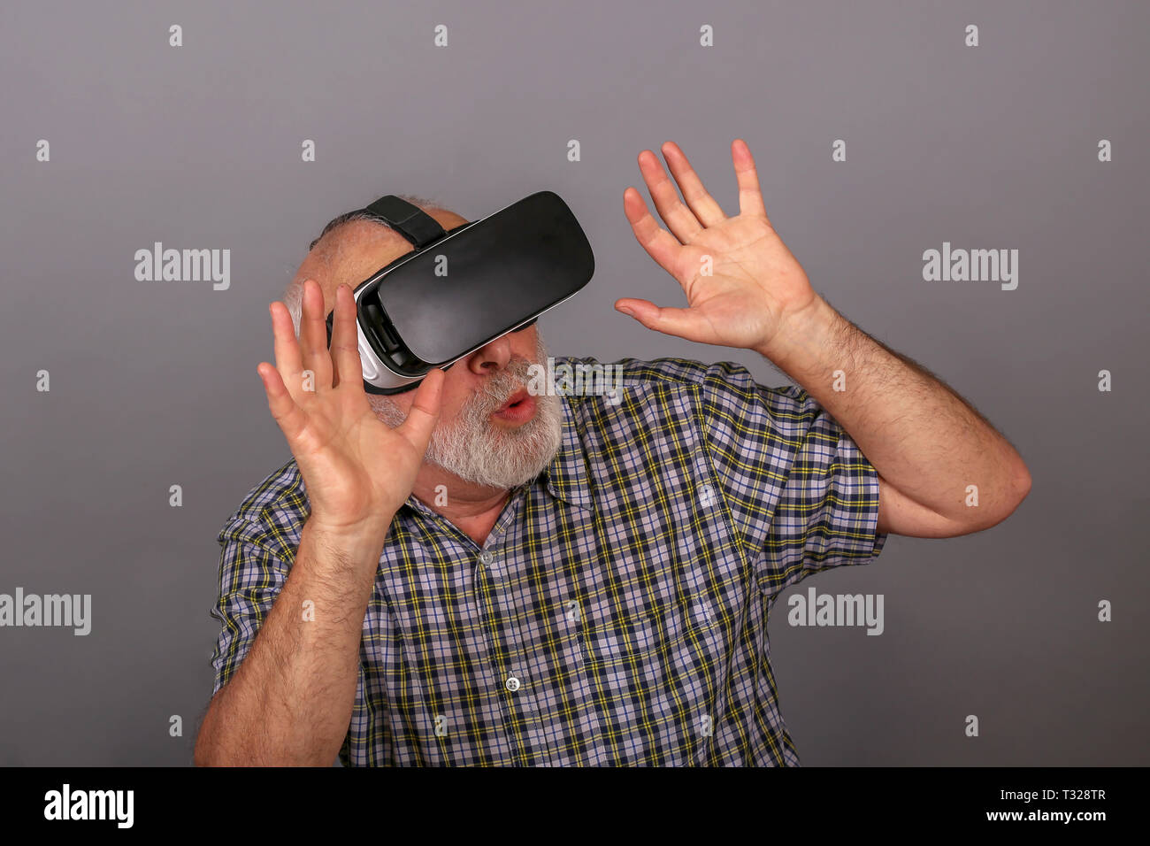 Man wearing virtual reality goggles. Studio shot, gray background Stock Photo