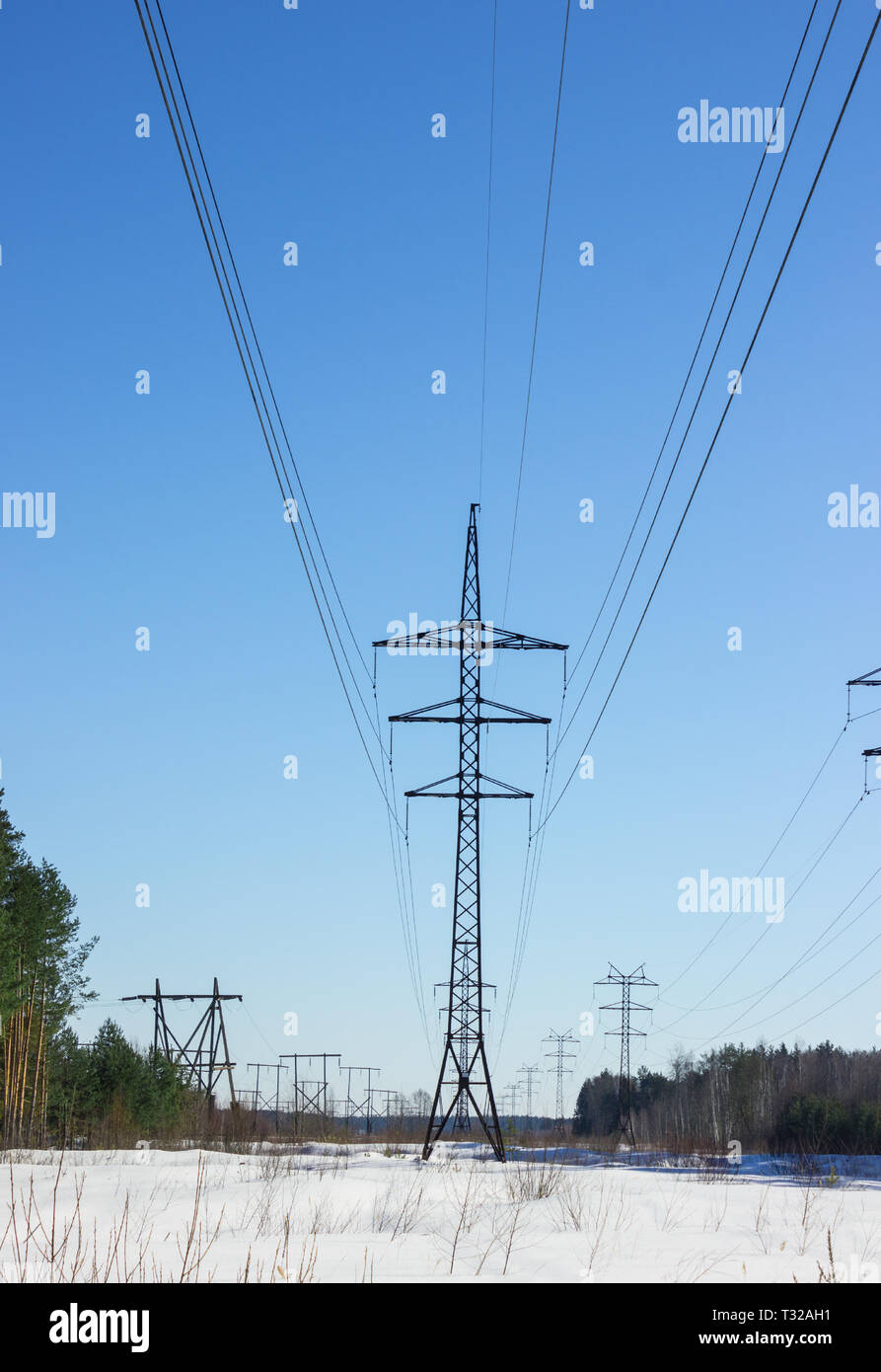 Powerful line of electricity costing in snow on a background of blue ...
