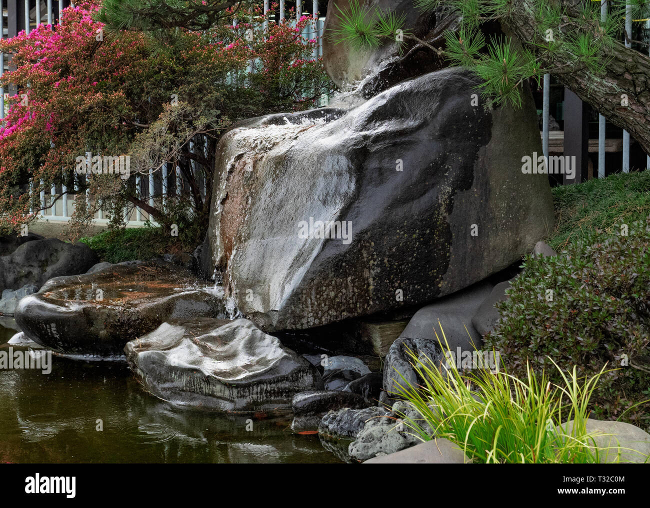 View of small waterfall ends in the goldfish tank in a flower garden Stock ...