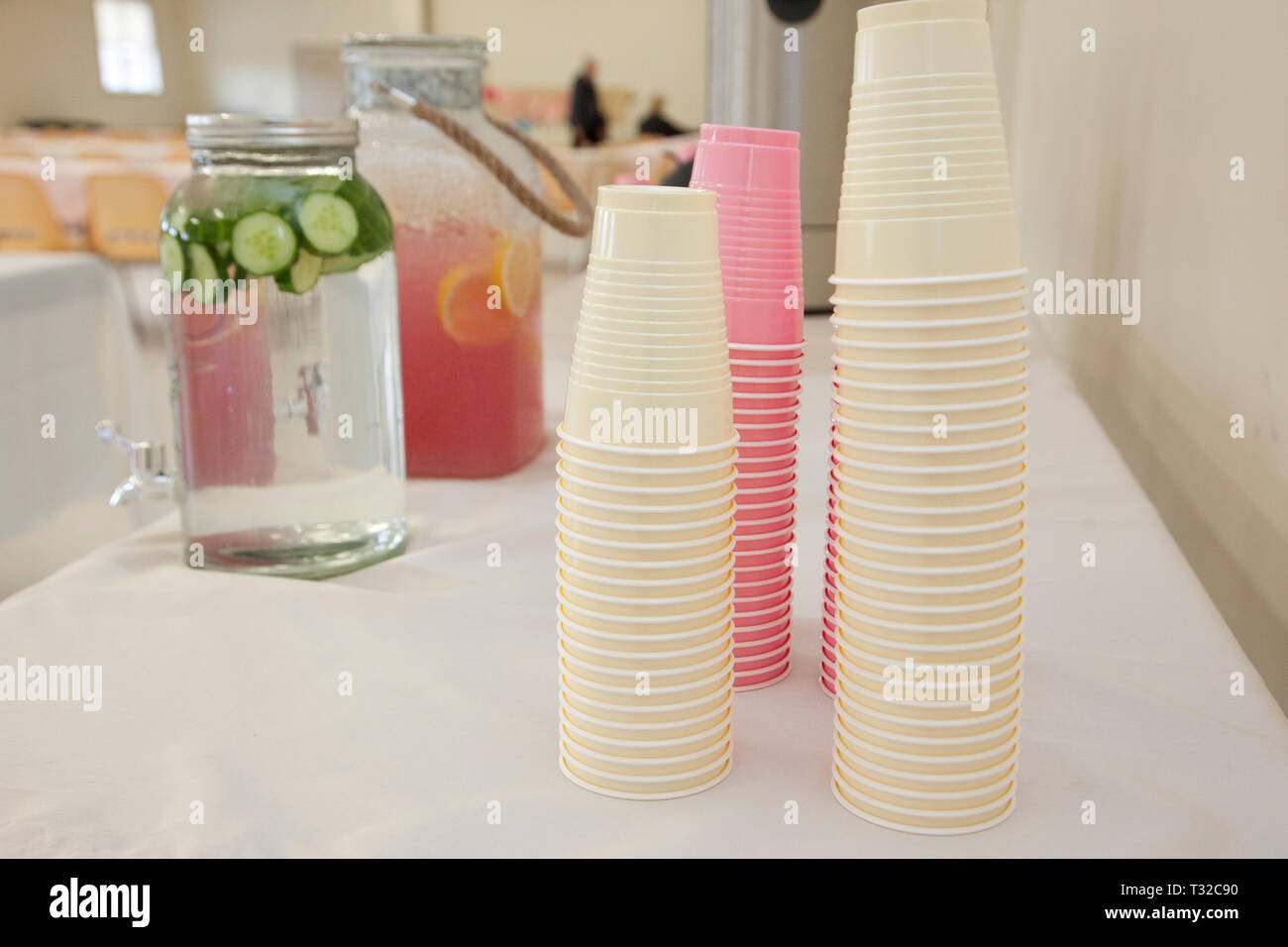 pink and white plastic cups ready to be filled from a container of