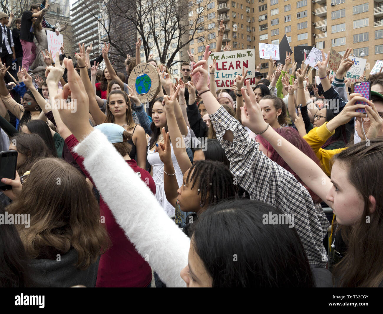 New York City, USA. 15th March, 2019. NYC Youth Climate Strike at Columbus Circle. Students signal for moment of silence. Stock Photo