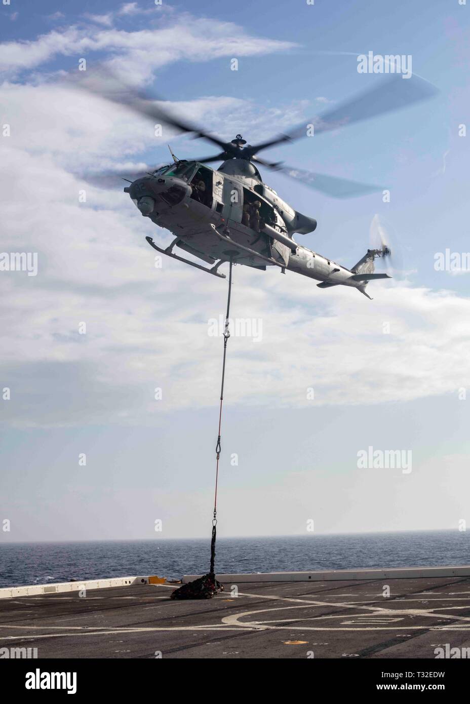 190401-N-HG389-0083 MEDITERRANEAN SEA (April 1, 2019) A UH-1Y Huey helicopter assigned to the “Black Knights” of Marine Medium Tiltrotor Squadron (VMM) 264 (Reinforced) lifts pallets from the flight deck of the San Antonio-class amphibious transport dock ship USS Arlington (LPD 24), April 1, 2019. Arlington is on a scheduled deployment as part of the Kearsarge Amphibious Ready Group in support of maritime security operations, crisis response and theater security cooperation, while also providing a forward naval presence. (U.S. Navy photo by Mass Communication Specialist 2nd Class Brandon Parke Stock Photo