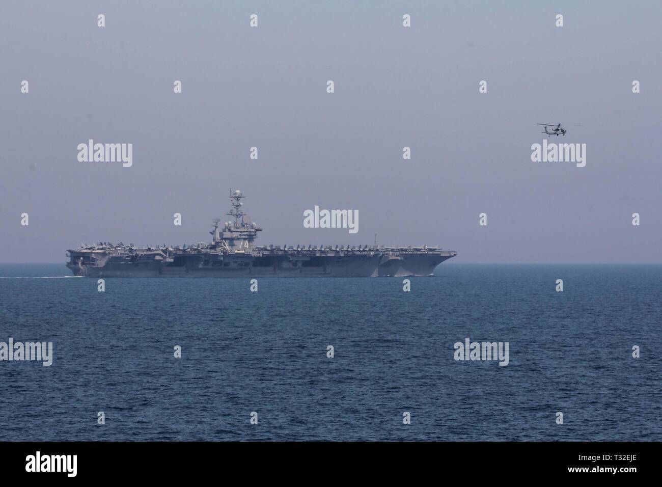 190329-N-GC639-1059 ARABIAN GULF (March 23, 2019) An MH-60S helicopter assigned to Helicopter Sea Combat Squadron (HSC) 14, embarked aboard the aircraft carrier USS John C. Stennis (CVN 74), flies near John C. Stennis while transiting the Arabian Gulf, March 29, 2019. The John C. Stennis Carrier Strike Group is deployed to the U.S. 5th Fleet area of operations in support of naval operations to ensure maritime stability and security in the Central Region, connecting the Mediterranean and the Pacific through the western Indian Ocean and three strategic choke points. (U.S. Navy photo by Mass Comm Stock Photo