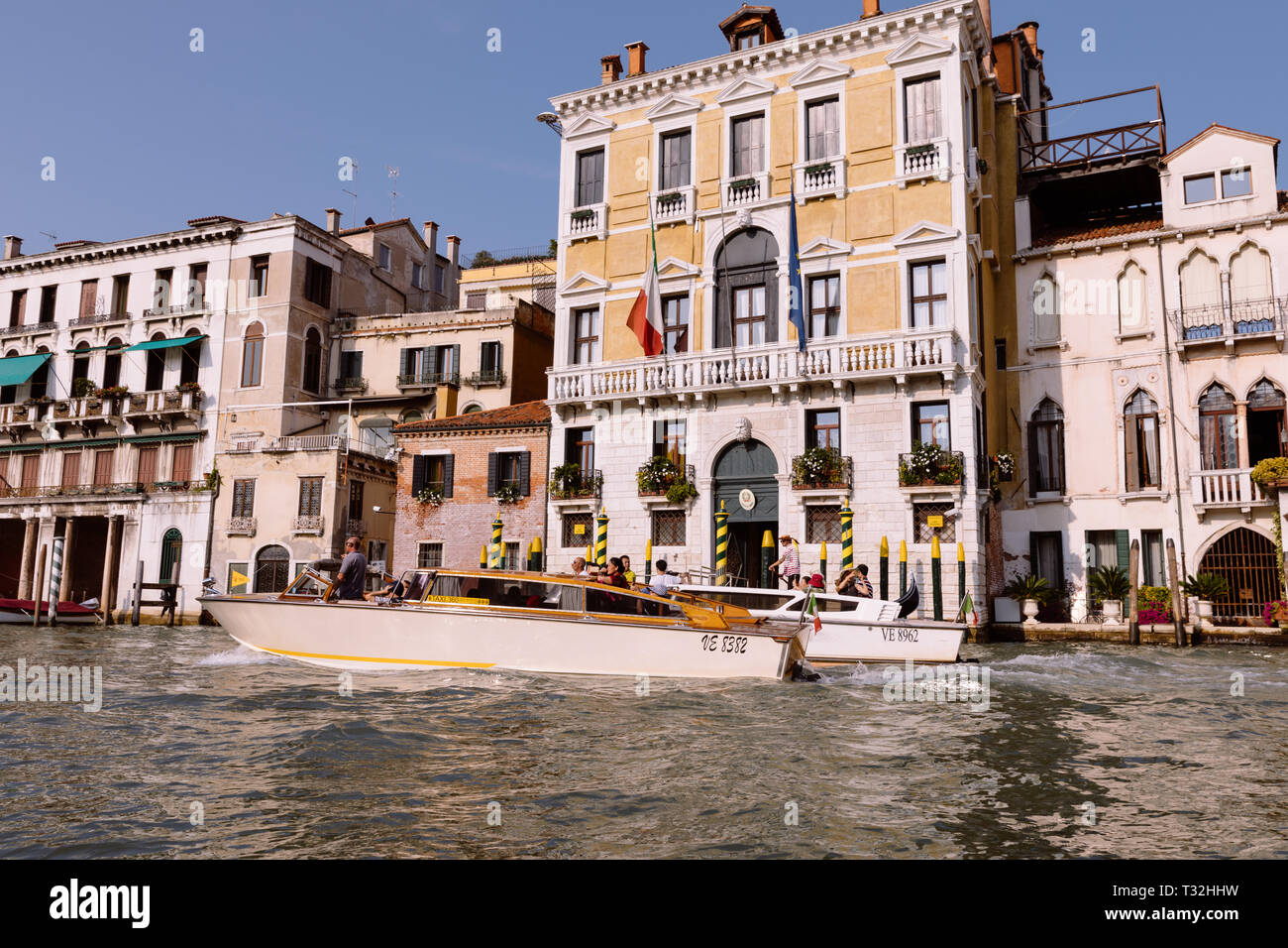 Venice, Italy - July 2, 2018: Closeup photography of motorboats with people and historical buildings of Grand Canal (Canal Grande) from gondola. Summe Stock Photo
