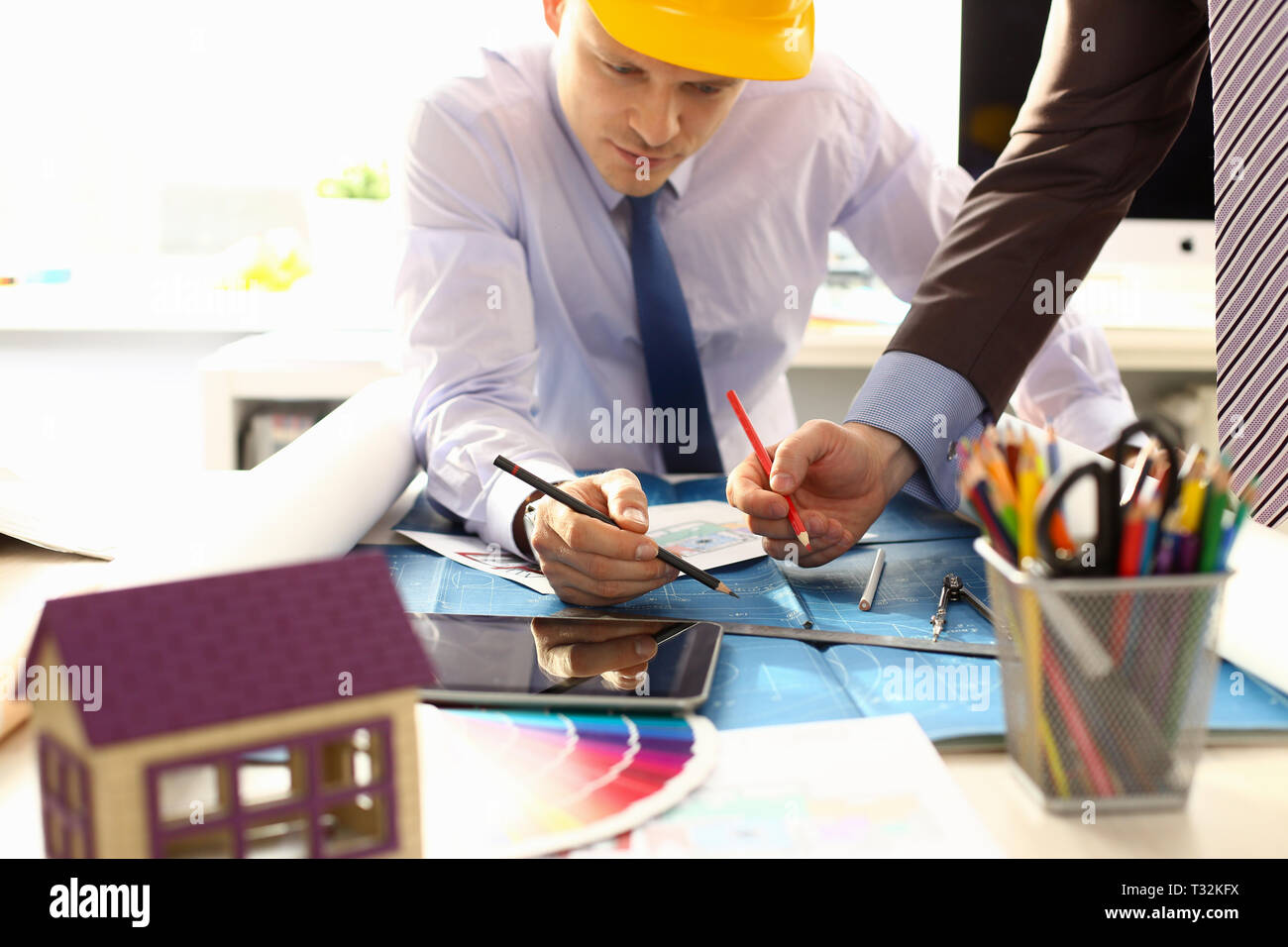 Two male workers examining blueprint papers Stock Photo