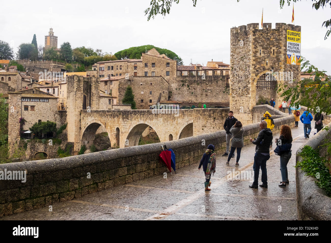 Tourists on the medieval bridge of Besalu, Catalonia adorned with a banner calling for the release of Catalan political prisoners Stock Photo