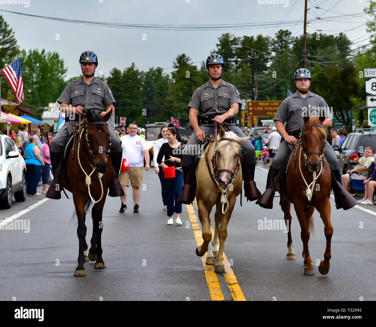 Three New York State Police officers riding horses in the 4th of July