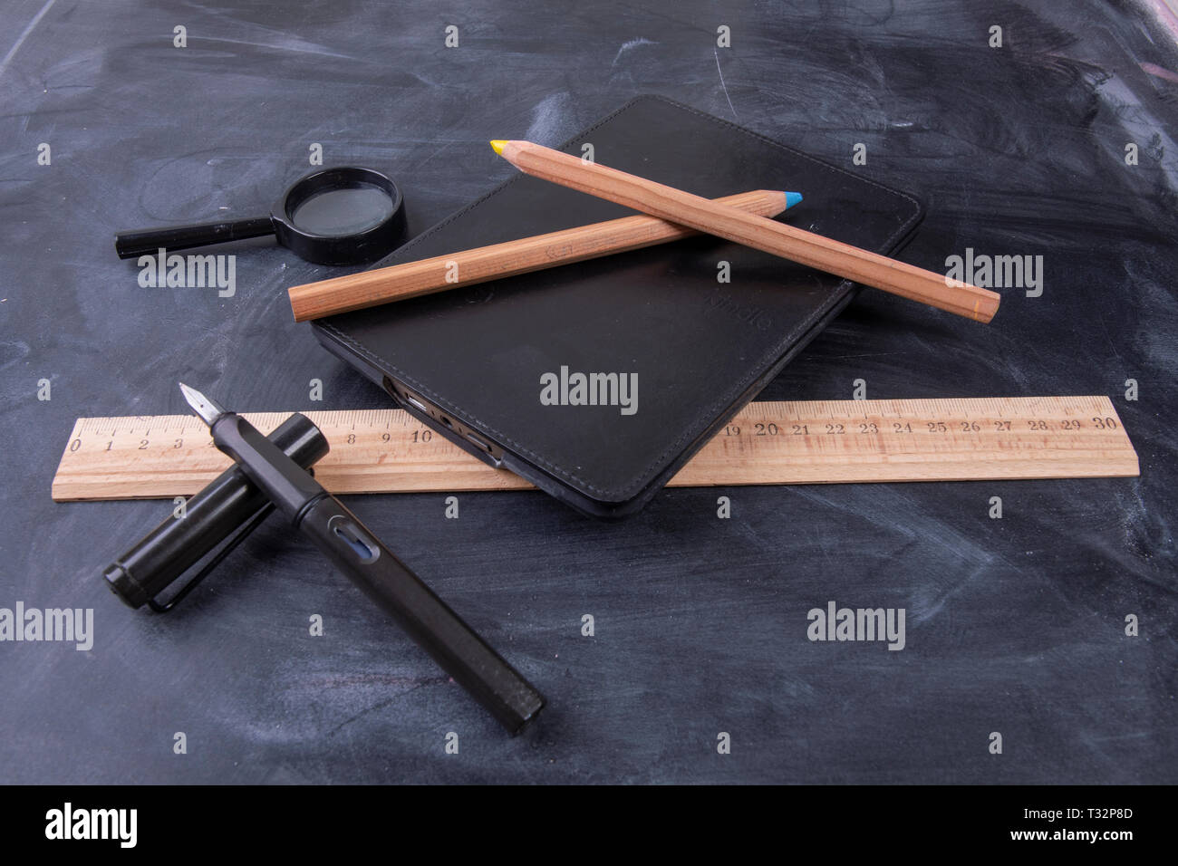 Magnifying glass fountain pen and ruler with a notebook on the ...