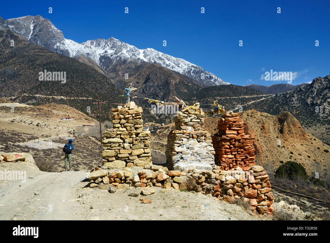 Trekker passing by a chorten near the village of Samar , Upper Mustang region, Nepal. Stock Photo