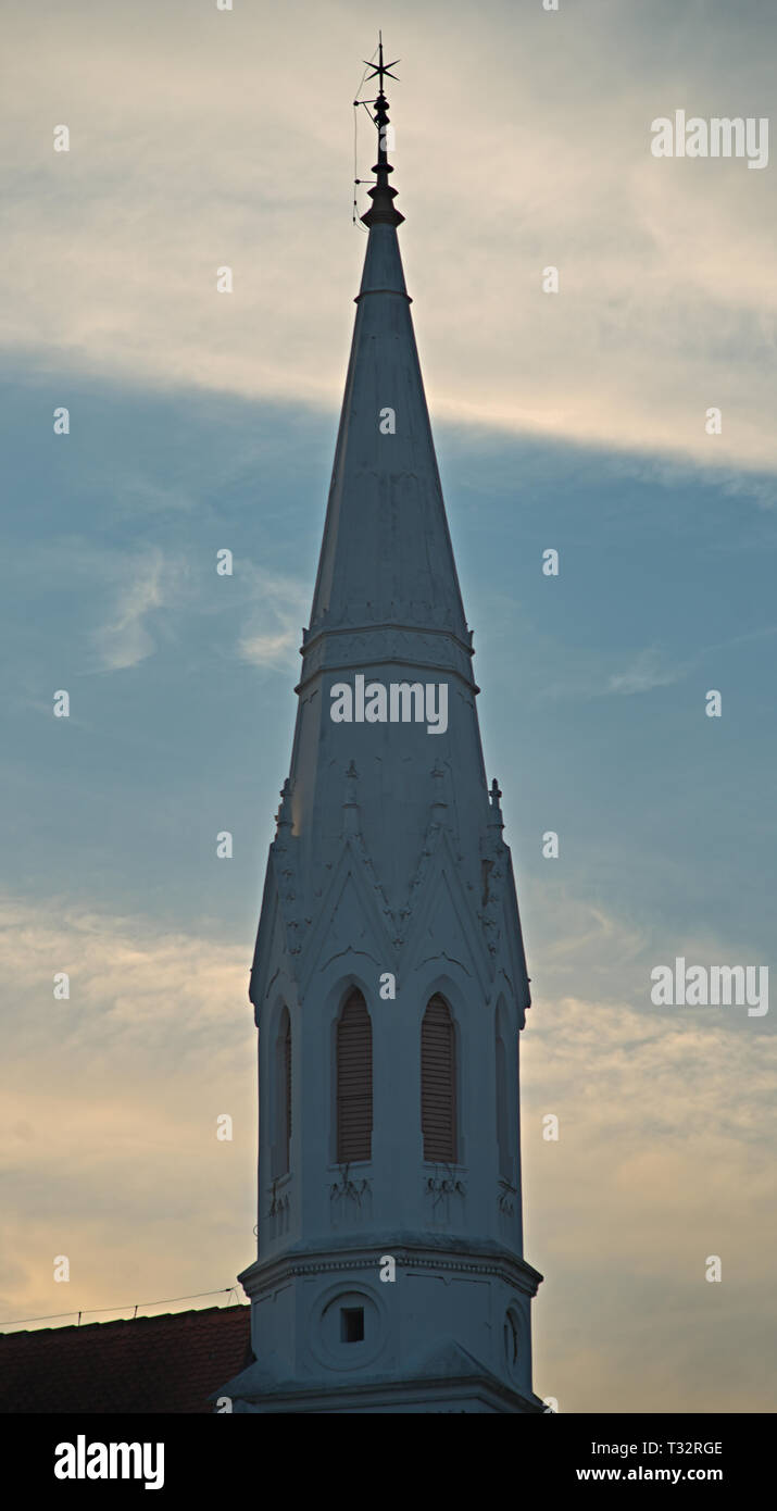 Old white bell tower of a protestant church against cloudy sky Stock Photo