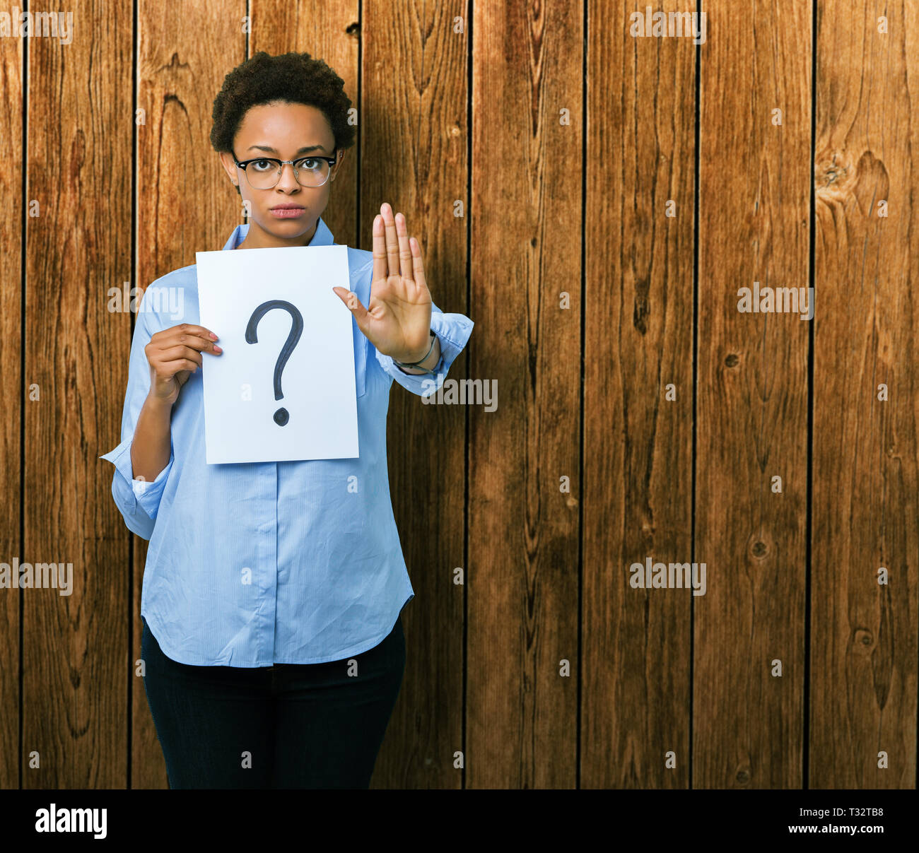 Young african american woman holding paper with question mark over ...