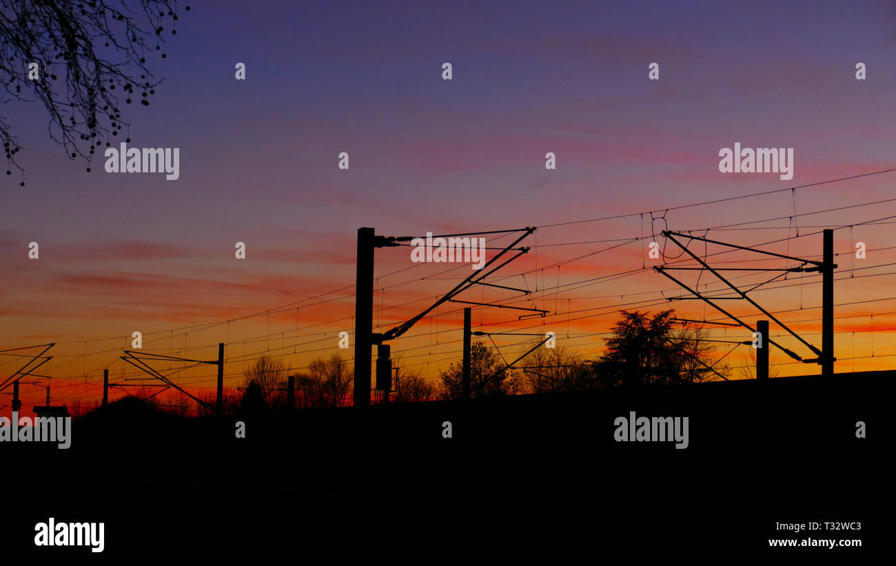Bahngleise, Oberleitungen,  Silhouette mit Bäumen, im Sonnenuntergang Stock Photo