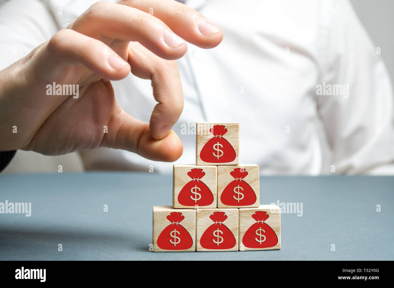 Businessman removes a cube with a picture of dollars. Bankruptcy concept. Economic recession. Financial crisis. Capital outflow. Sabotage of the econo Stock Photo