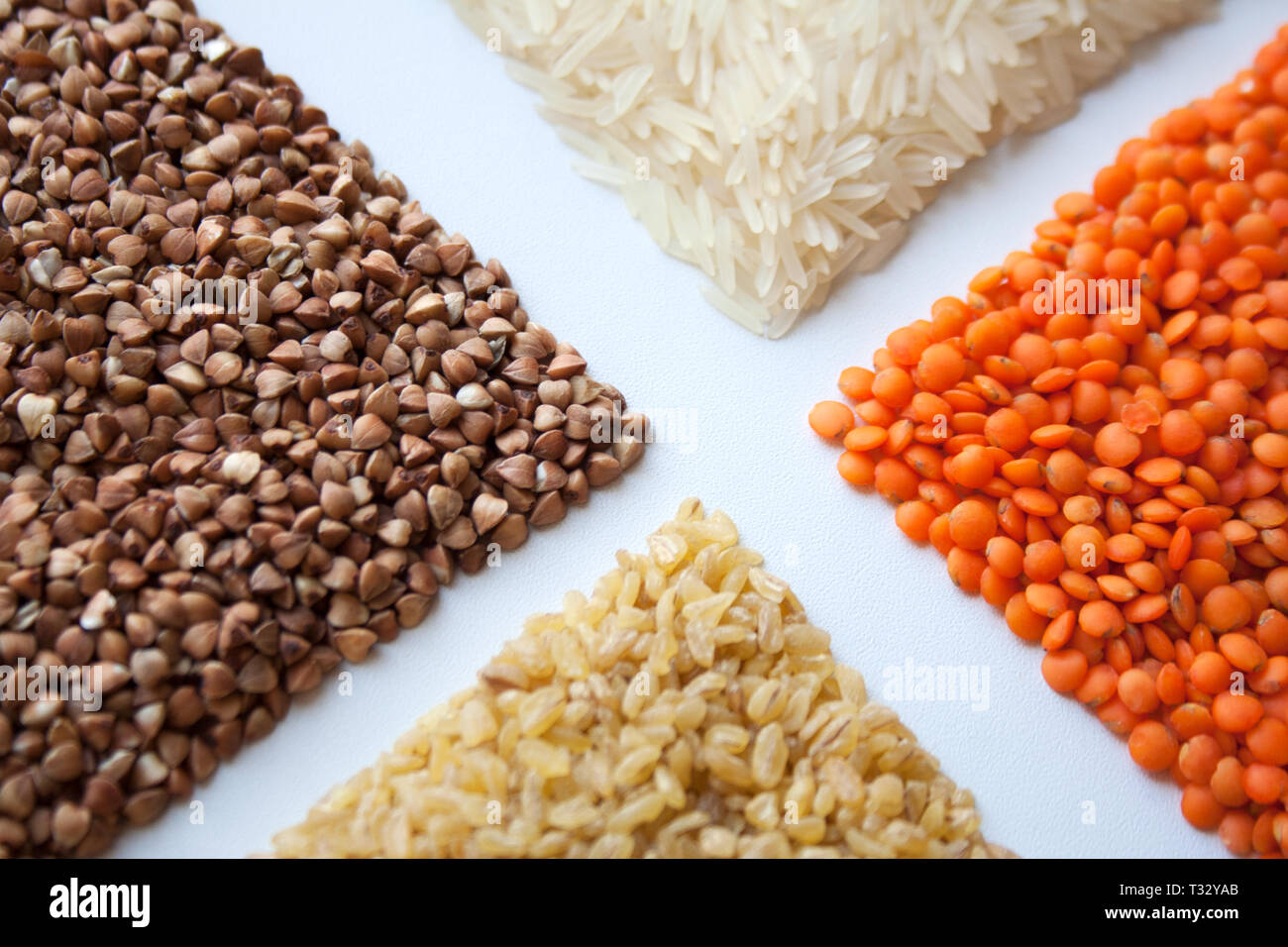Raw buckwheat, red lentils, bulgur and basmati rice isolated on white ...