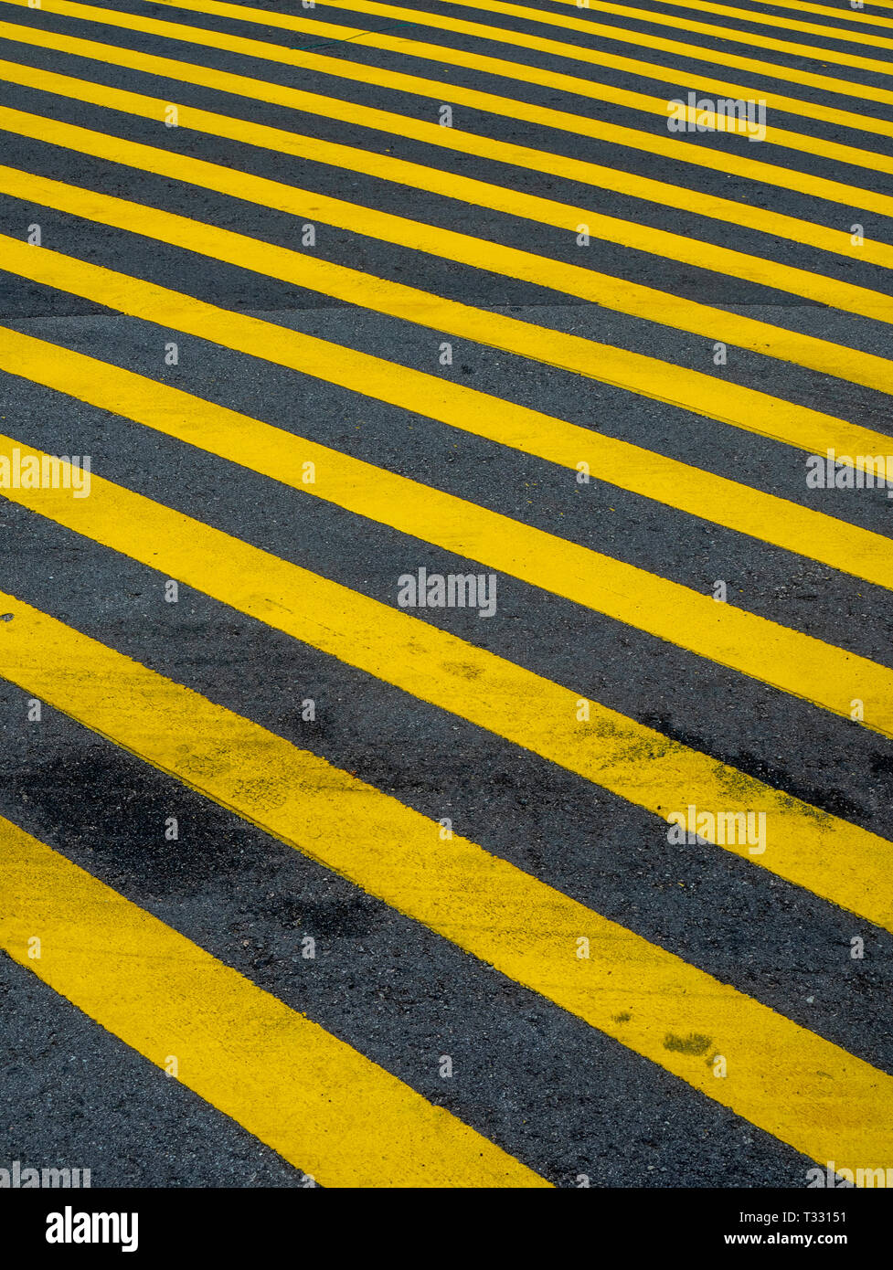 yellow stripes painted on a road. Stock Photo