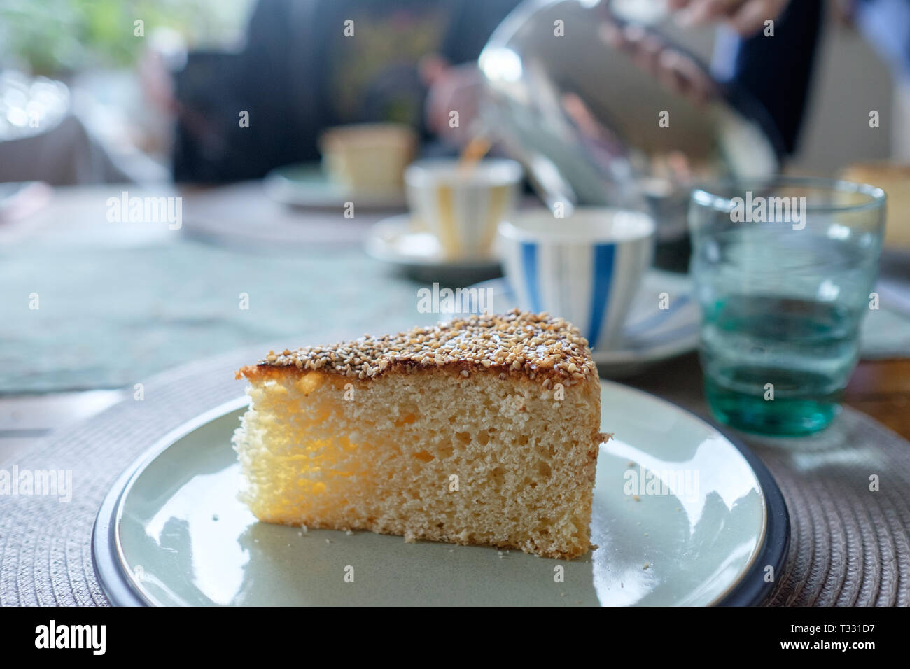 A slice of homemade vasilopita, a traditional Greek New Year's cake topped with sesame seeds. The vasilopita is cut at the stroke of midnight with a l Stock Photo