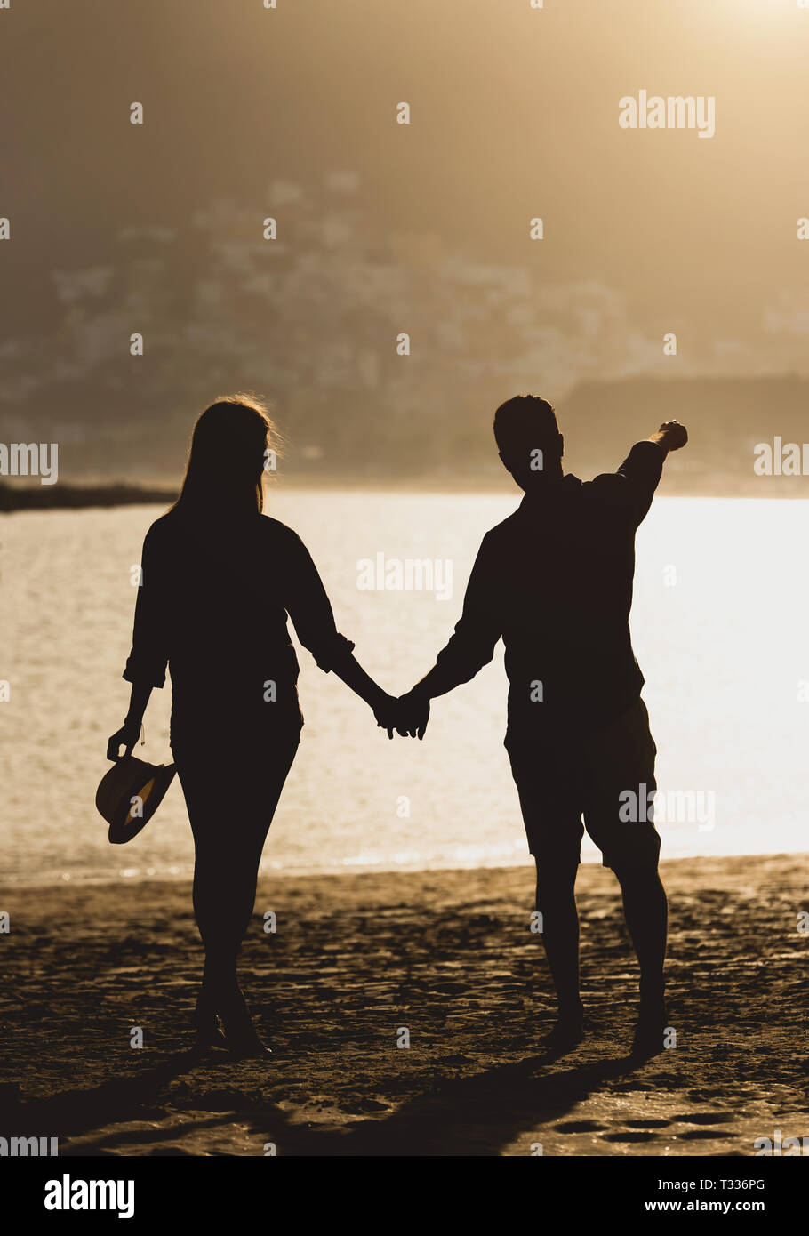 Silhouette Of A Couple Holding Hands On Beach At Sunset High Resolution ...