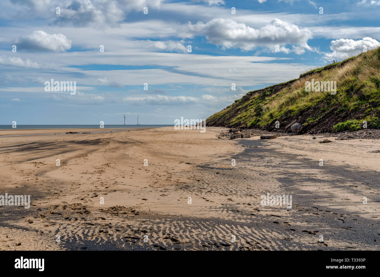 North Sea coast in Cambois, Northumberland, England, UK - the beach with wind turbines in the background Stock Photo