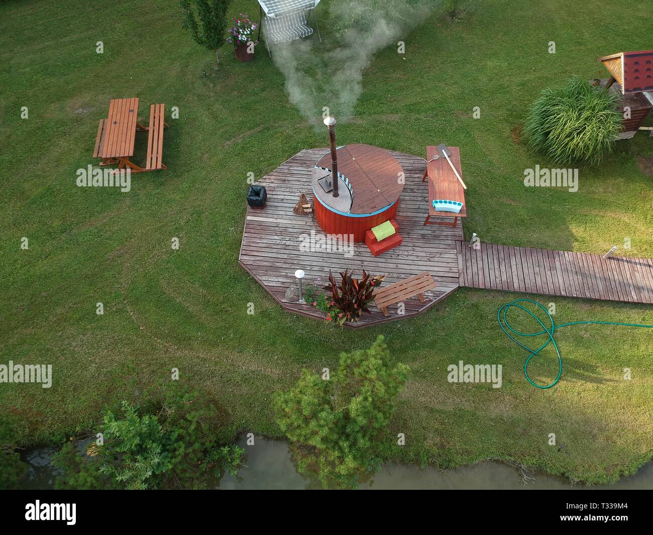 outdoor wooden barrel bath in summer garden park, aerial view Stock Photo