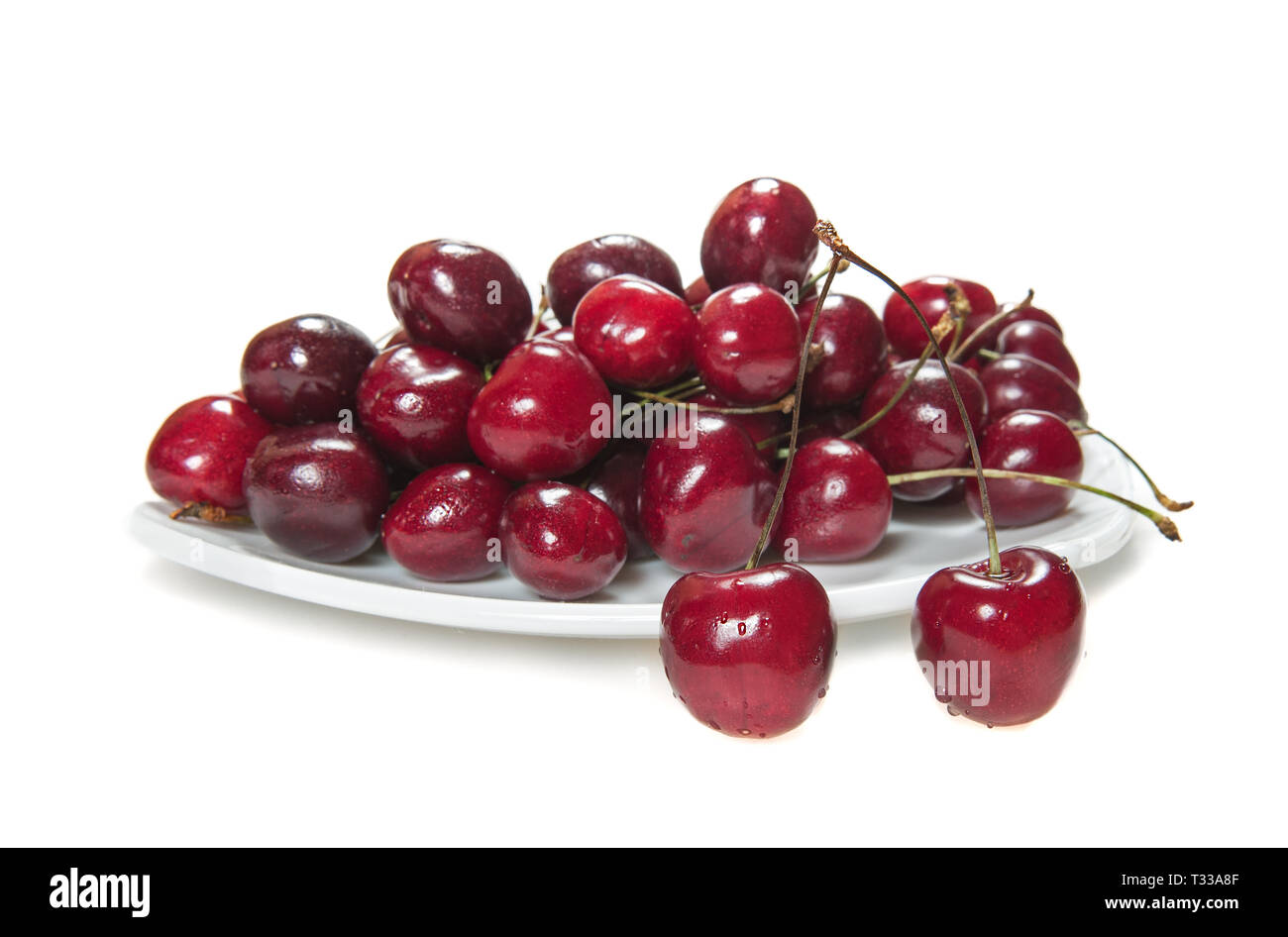 Fresh sweet cherries dish with water drops on white background Stock Photo