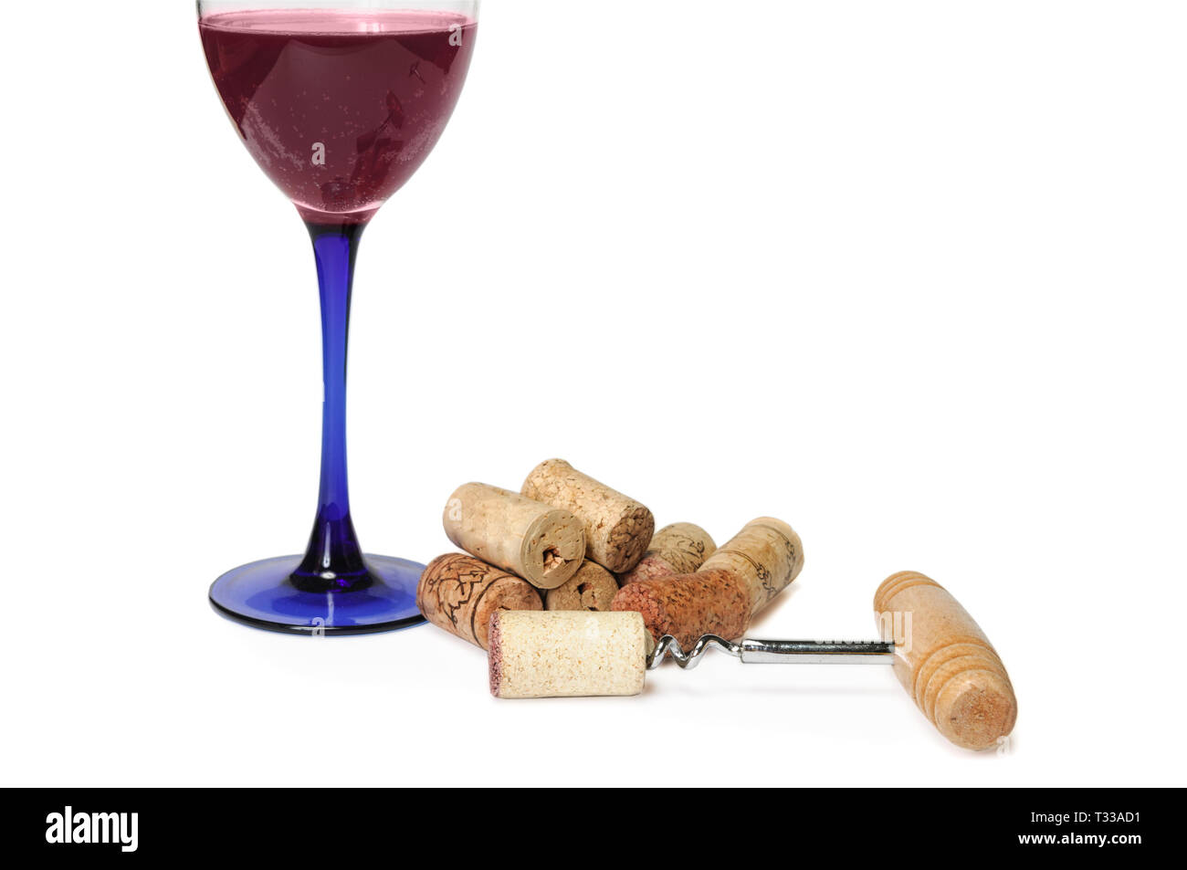 Glass of red sparkling wine near pile of corks and corkscrew isolated on white. Clipping path included. Copy space for your text Stock Photo