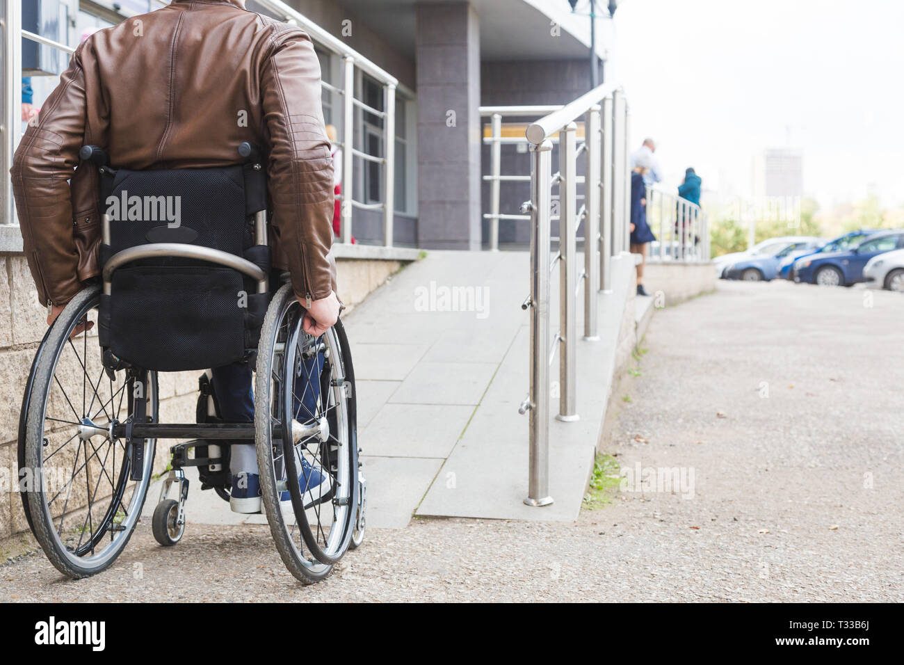 Man in a wheelchair use a wheelchair ramp Stock Photo - Alamy