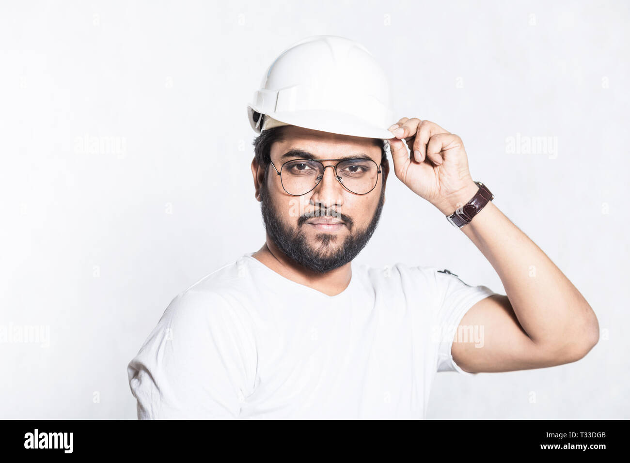 Young builder engineer with glasses and a white protective helmet Stock Photo