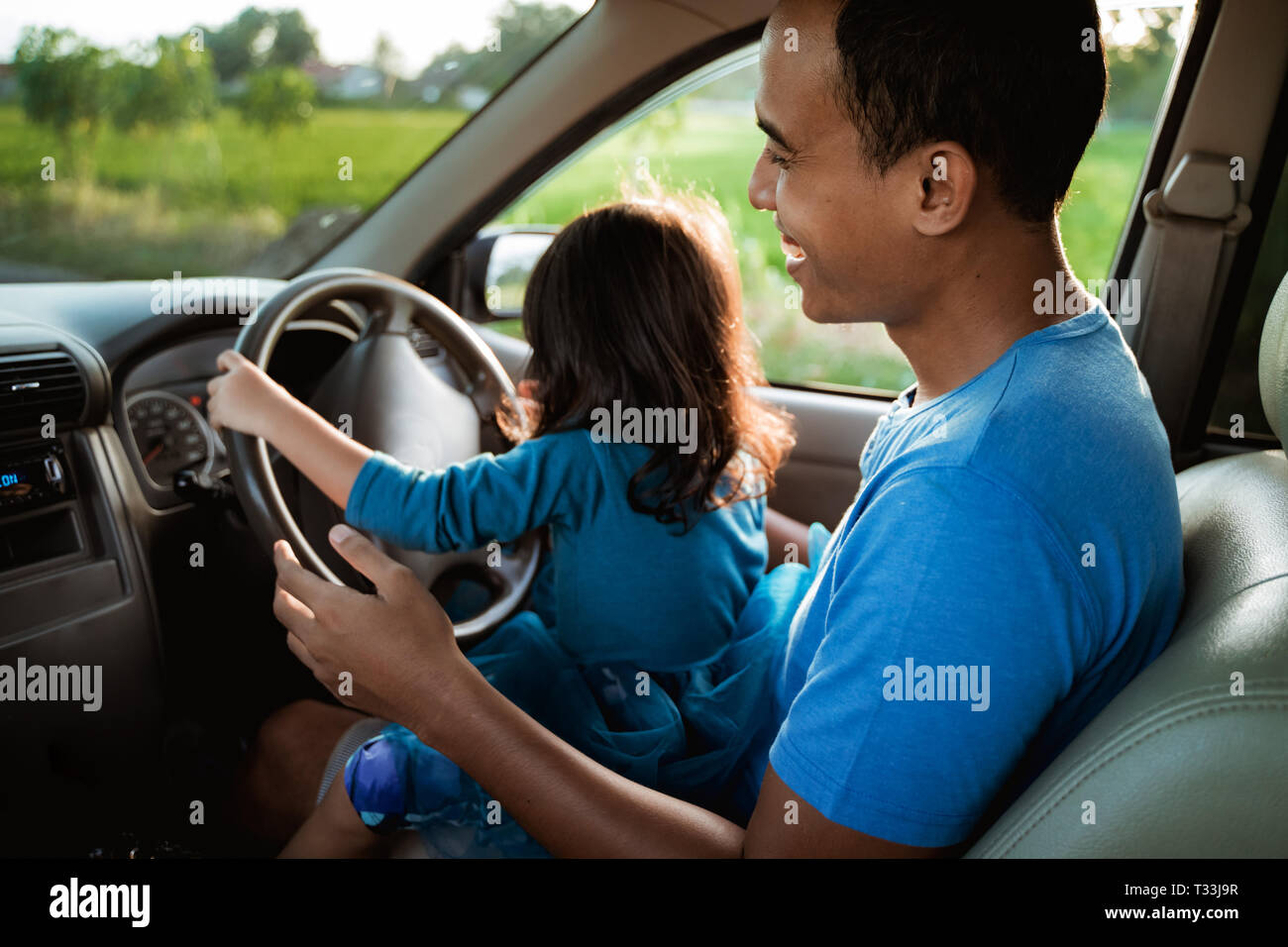 kid playing with steering wheel dad Stock Photo Alamy