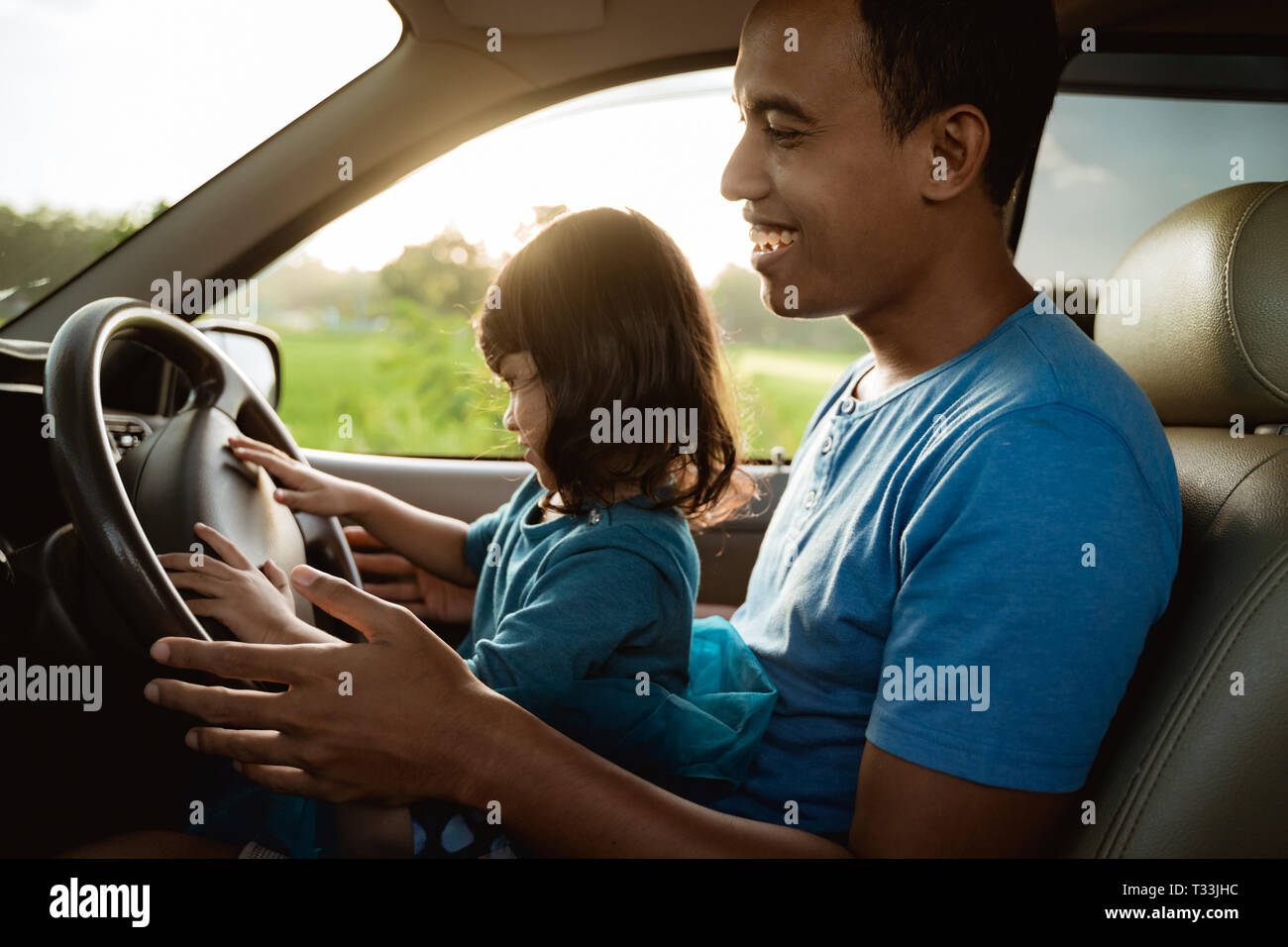 kid playing with steering wheel dad Stock Photo Alamy