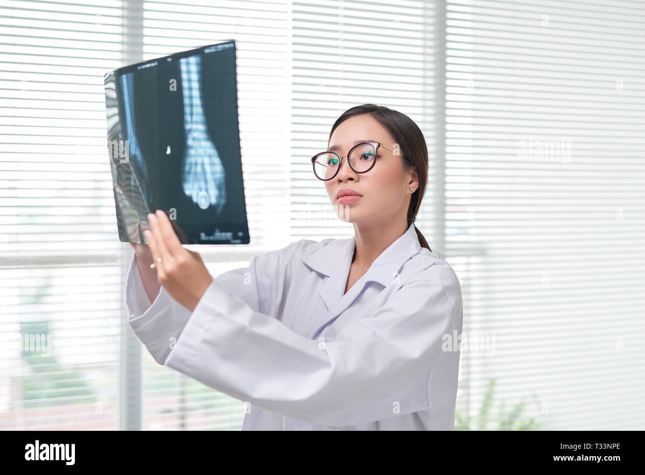 Woman in scrubs examining Xrays Stock Photo Alamy