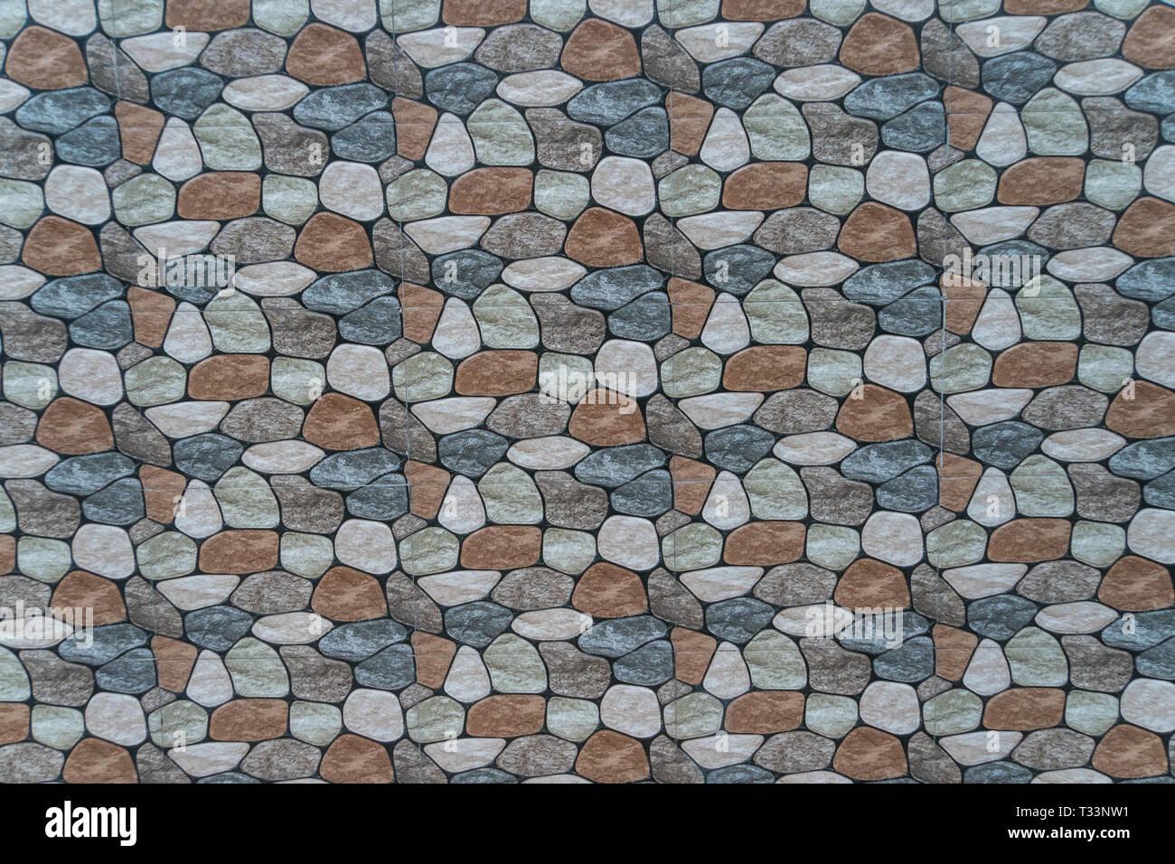 multicolored stone with rounded faces wall background. Seamless background Stock Photo