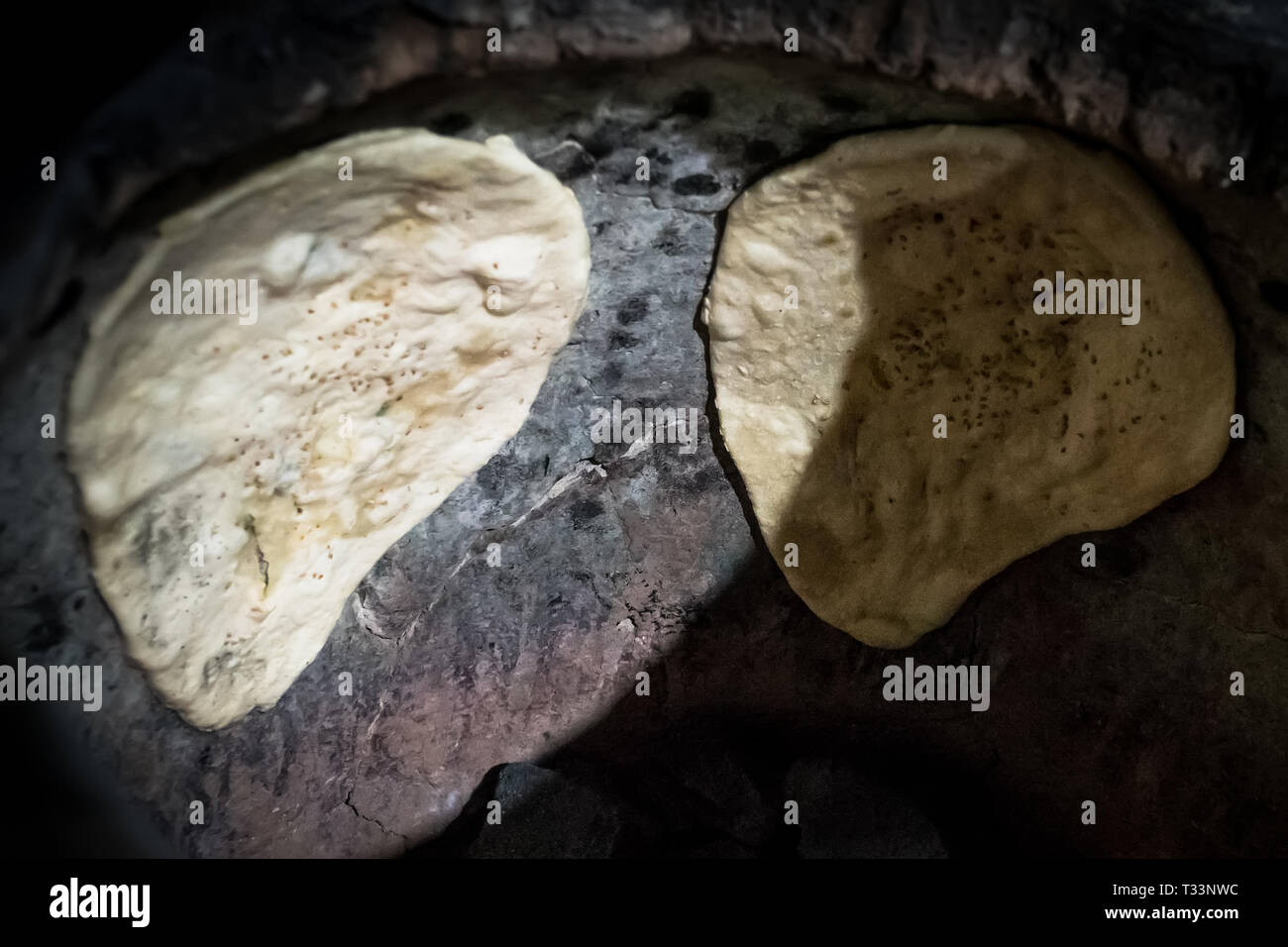 Indian flat bread 'Naan' making in original India tandoori clay oven in the evening Stock Photo