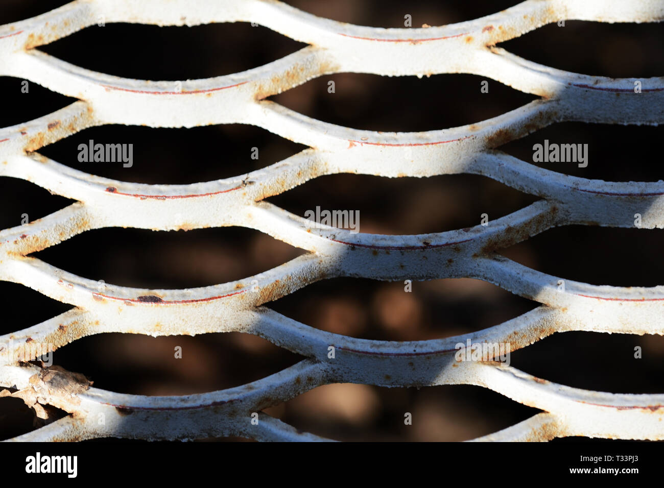 Old iron mesh illuminated by the sun close up. Abstract background Stock Photo