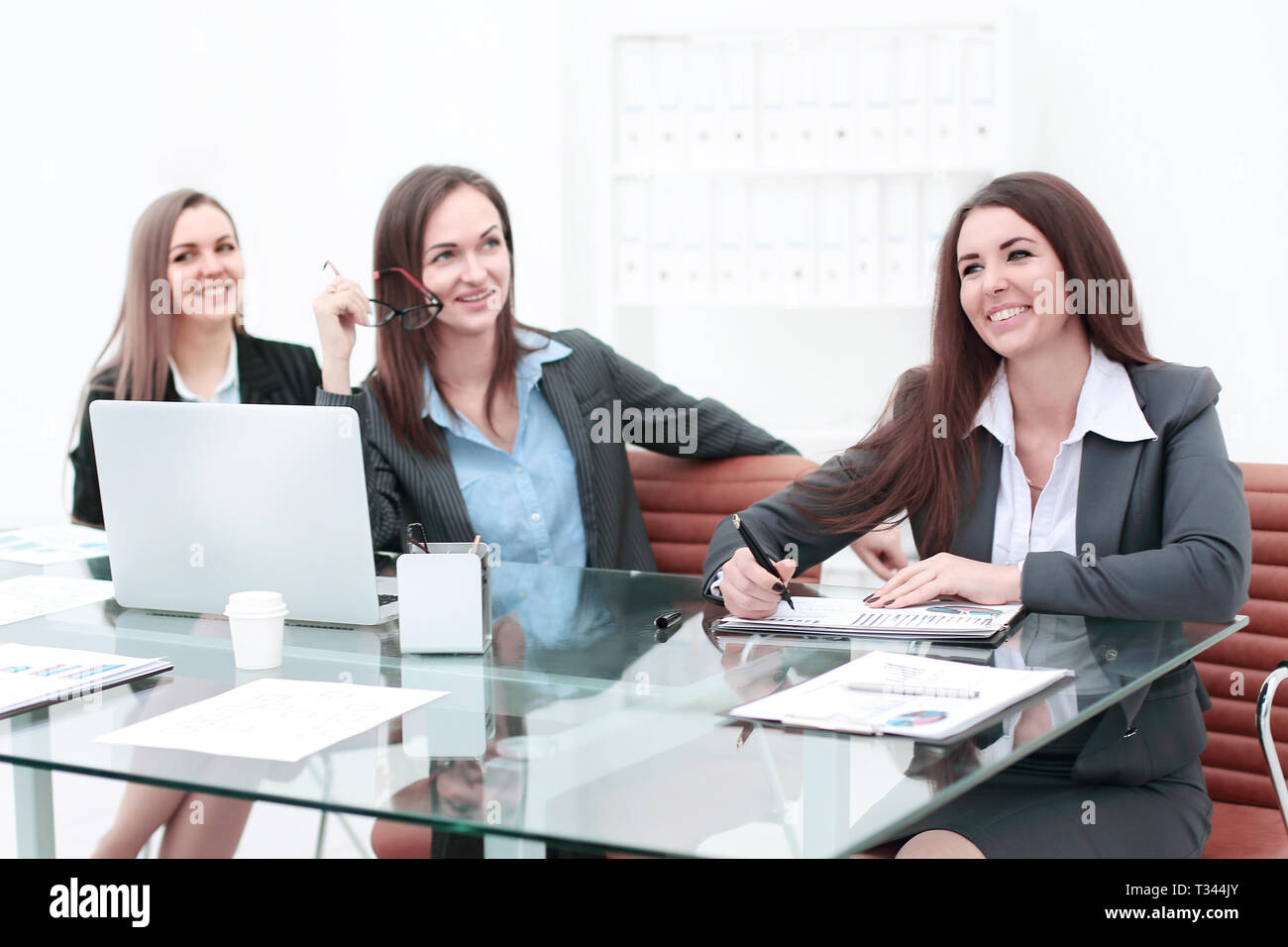 Three Businesswomen Meeting Around Table In Modern Office Stock Photo ...