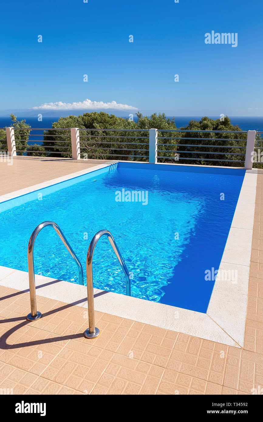 Water in blue greek swimming pool at sea with sky during summer season Stock Photo