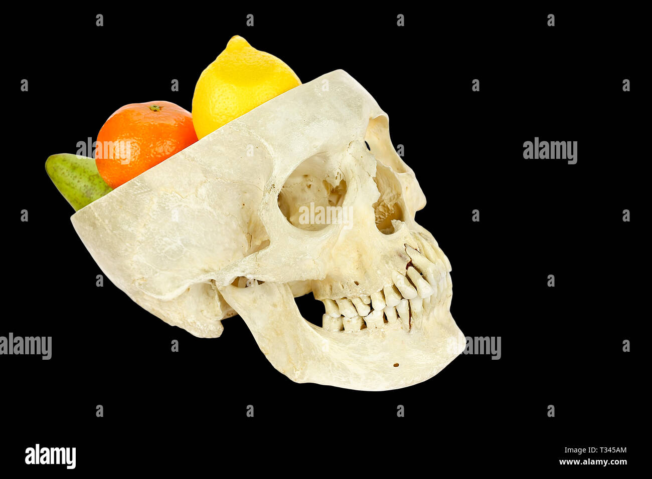 Human skull filled with fruits isolated on black background Stock Photo