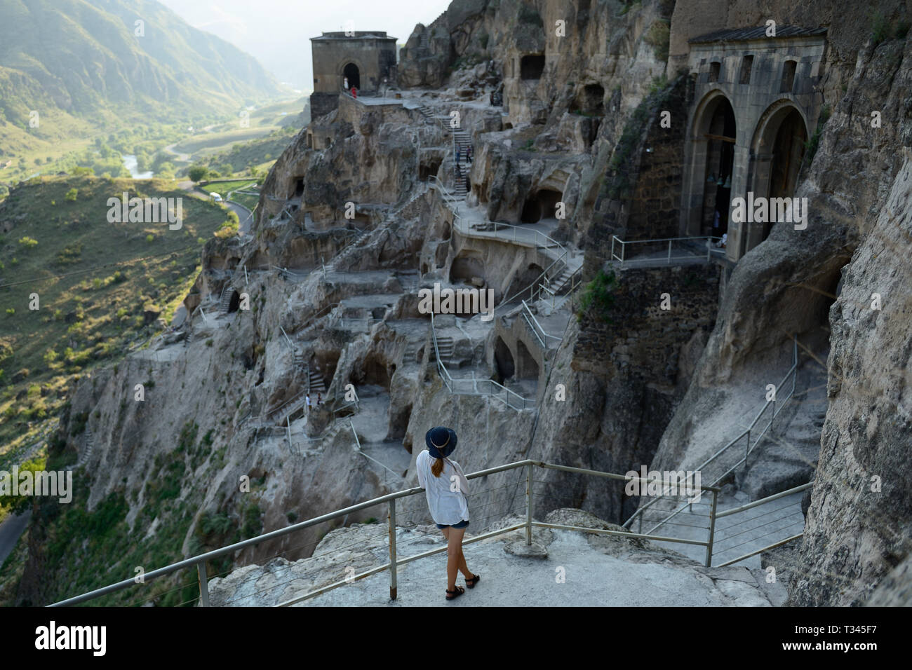 Tourist looking on the Vardzia cave monastery and ancient city in mountain rocks, one of the main attraction in Georgia, UNESCO Stock Photo