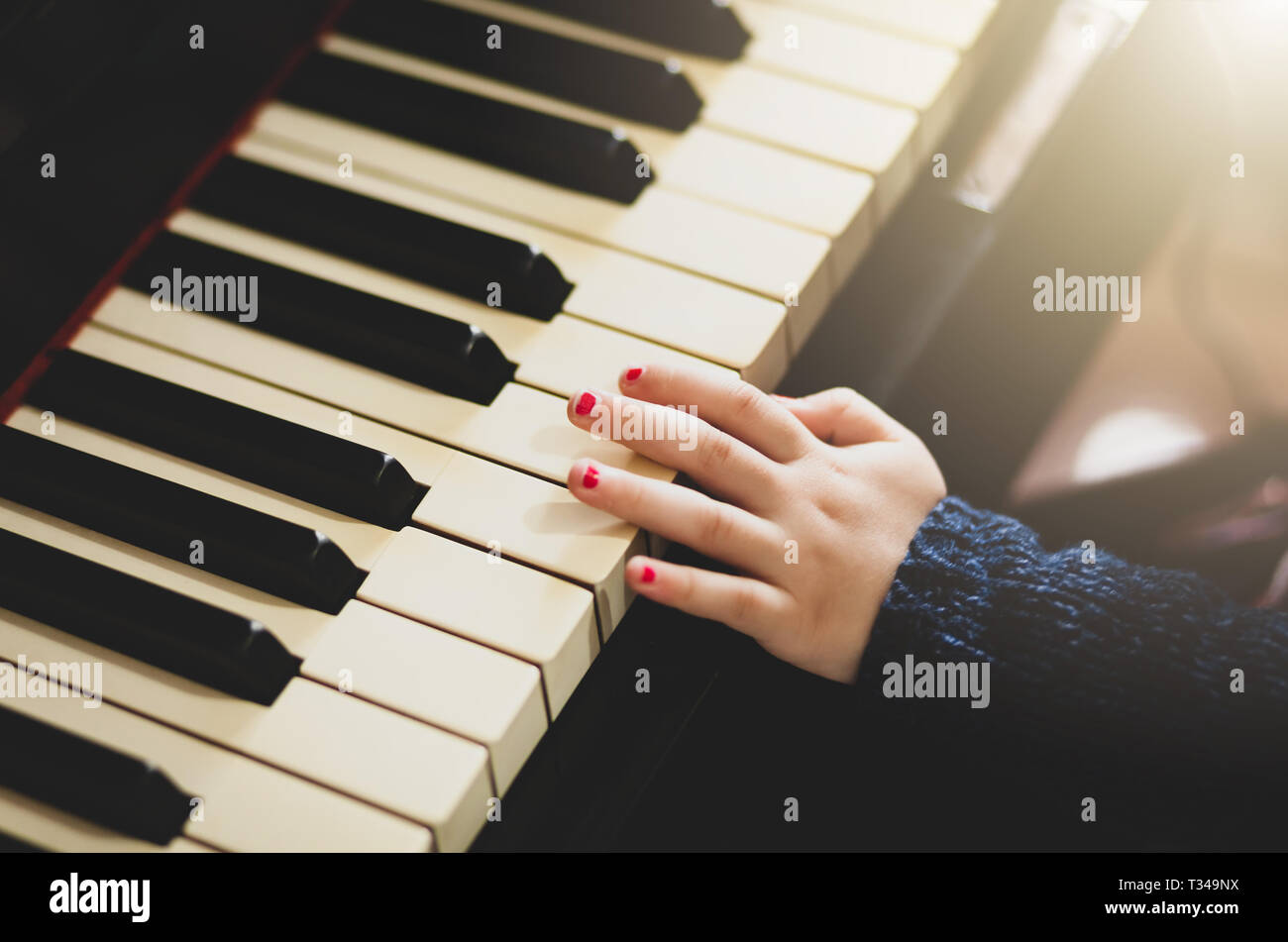 Close up of hand of girl toddler playing the piano. Stock Photo