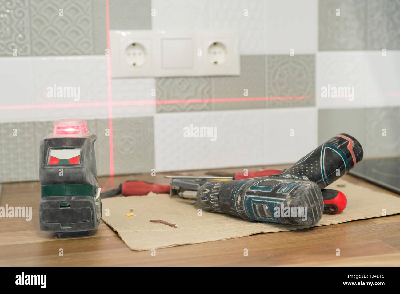 Electrician using infrared laser level to install electrical outlets