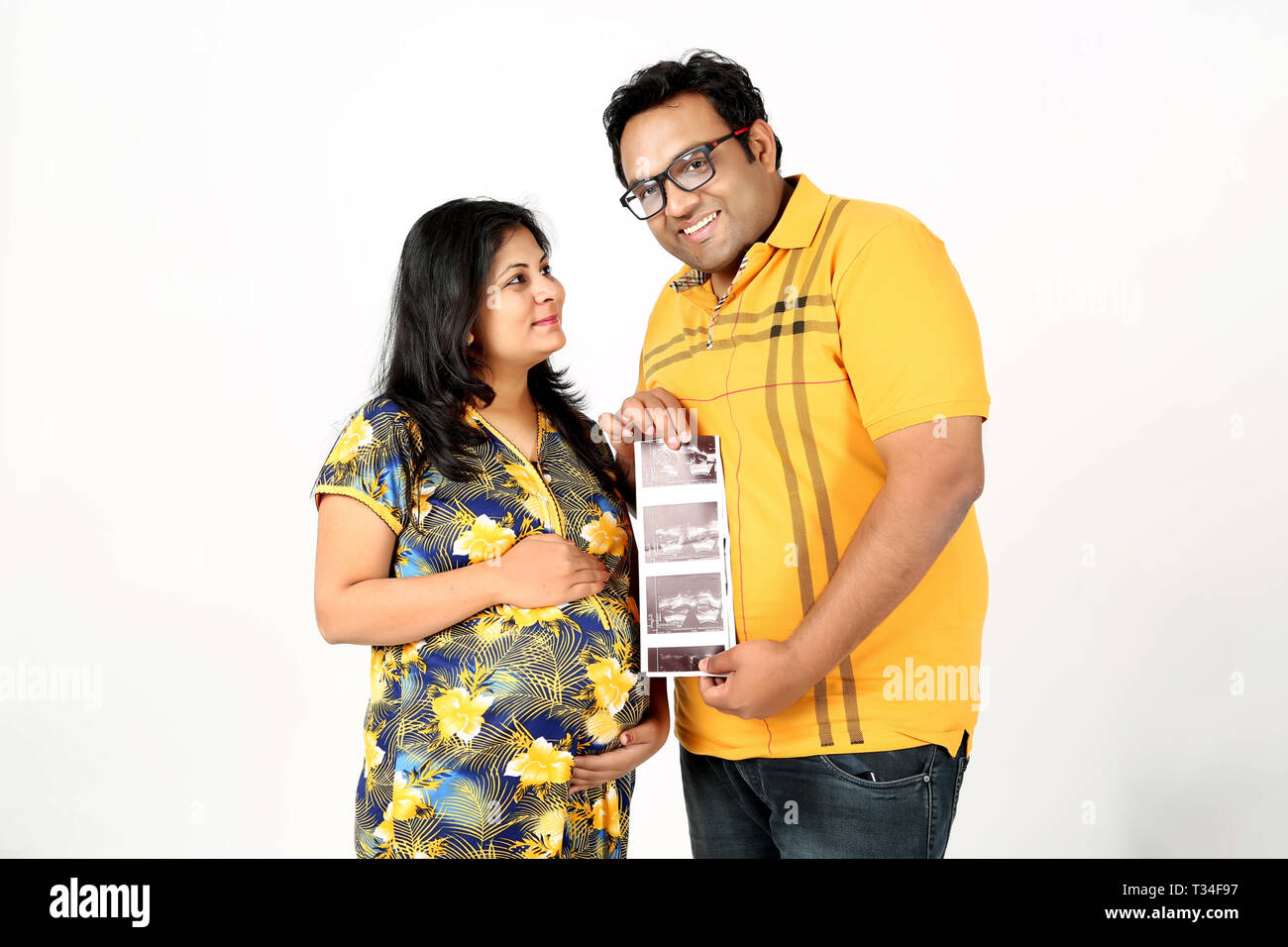 Picture of man is holding ultrasound in hand with pregnant wife ...