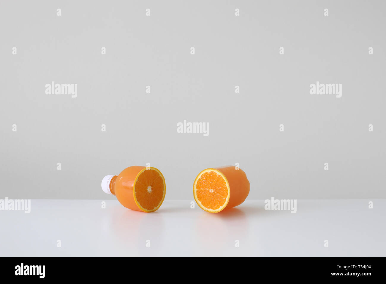 Conceptual orange juice bottle cut in half with a real orange inside Stock Photo