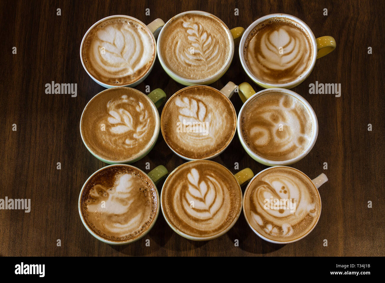 Nine cappuccino drinks with different froth decorations Stock Photo