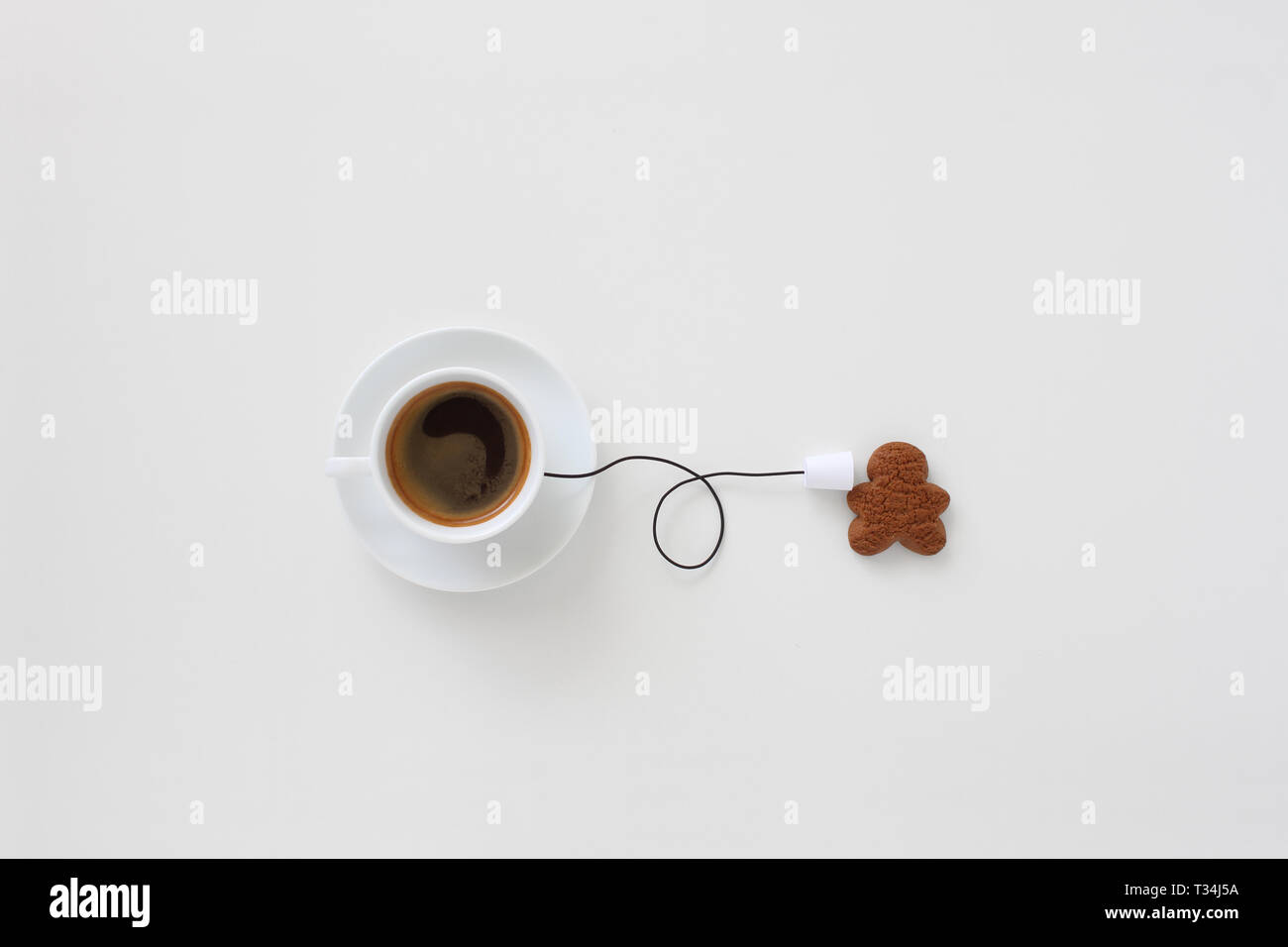 Conceptual cup of coffee string phone and a gingerbread man Stock Photo