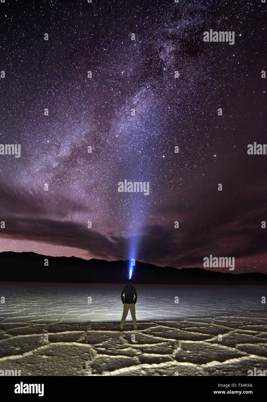Man standing in Badwater Basin wearing a headlamp, Death Valley National Park, Inyo County, California, United States Stock Photo