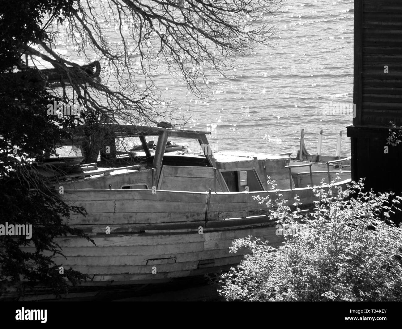 Abandoned black and white Boat on land at Lake Futalaufquen, Chubut, Argentina. Stock Photo