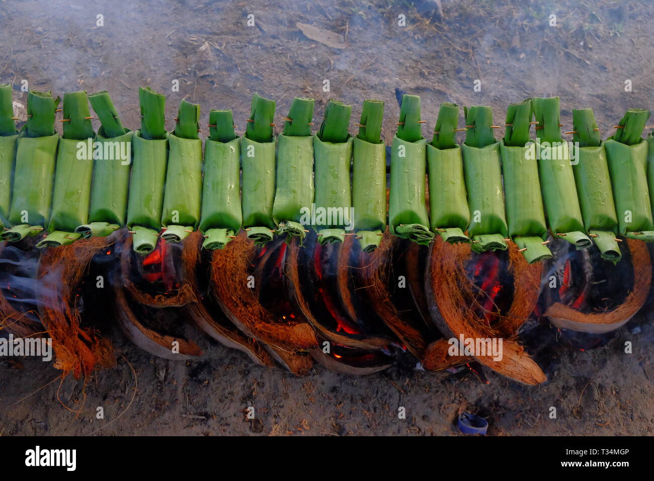 Grilled fish wrapped in banana leaves on a barbecue, Indonesia Stock