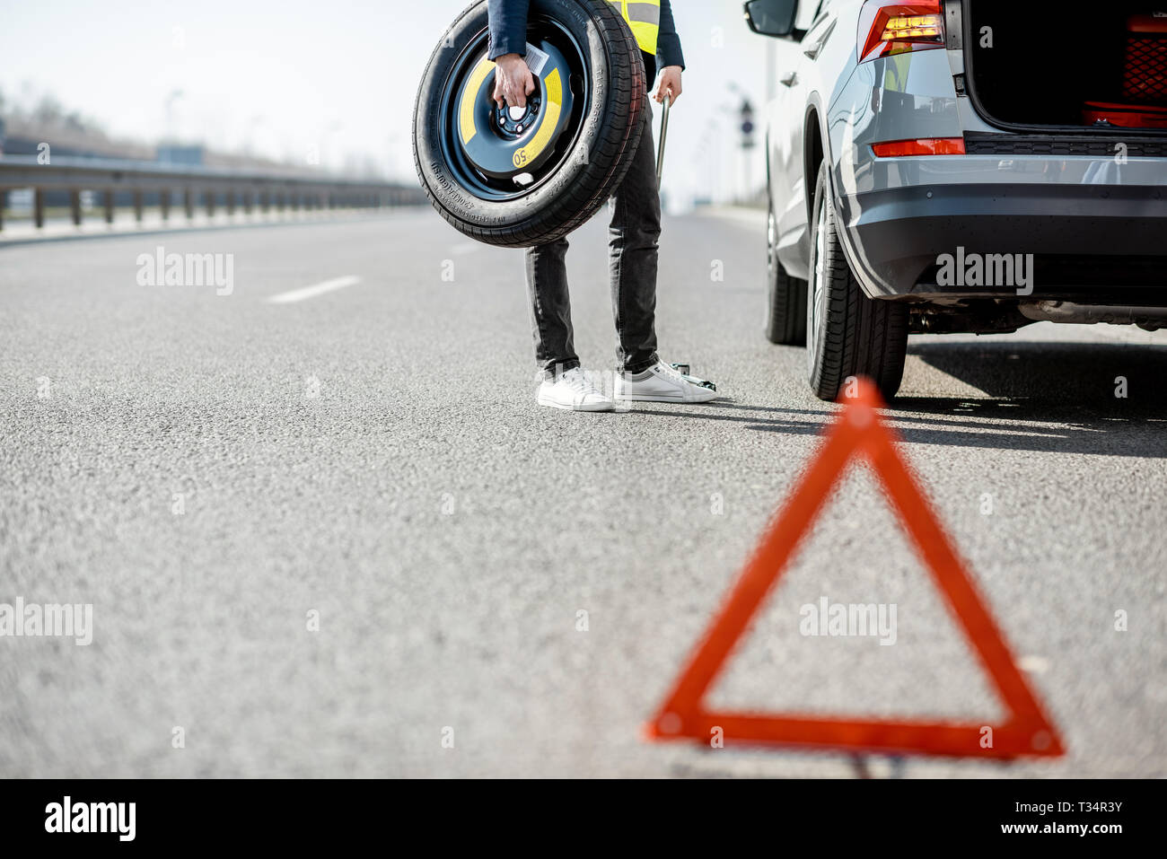 Man Changing Wheel Standing With Spare Wheel Near The Broken Car On The Roadside Stock Photo Alamy